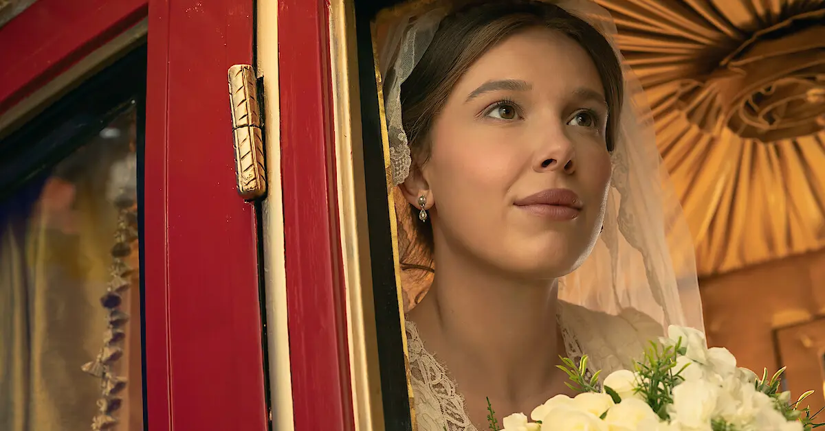 Enola Holmes vestida de novia contempla el camino desde un carruaje